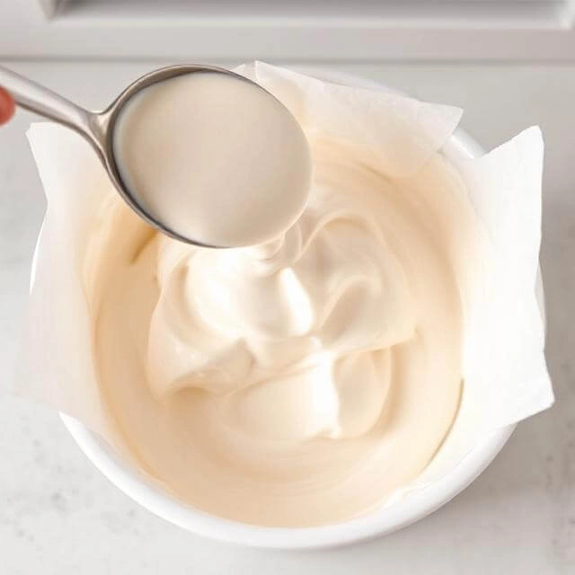 Transferring the protein ice cream mixture into a container for freezing.