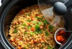 Easy Crockpot Recipes Packed with Protein and Flavor : Close-up of a crockpot filled with a colorful protein-rich dish of quinoa and vegetables, garnished with fresh herbs, showcasing the final touch of an easy, flavorful meal.