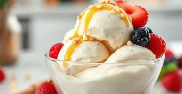 Homemade protein ice cream in a white bowl topped with fresh berries and almonds, healthy high-protein dessert.